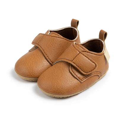 Pair of brown baby velcro loafers featuring a wide toe box and easy-on strap.