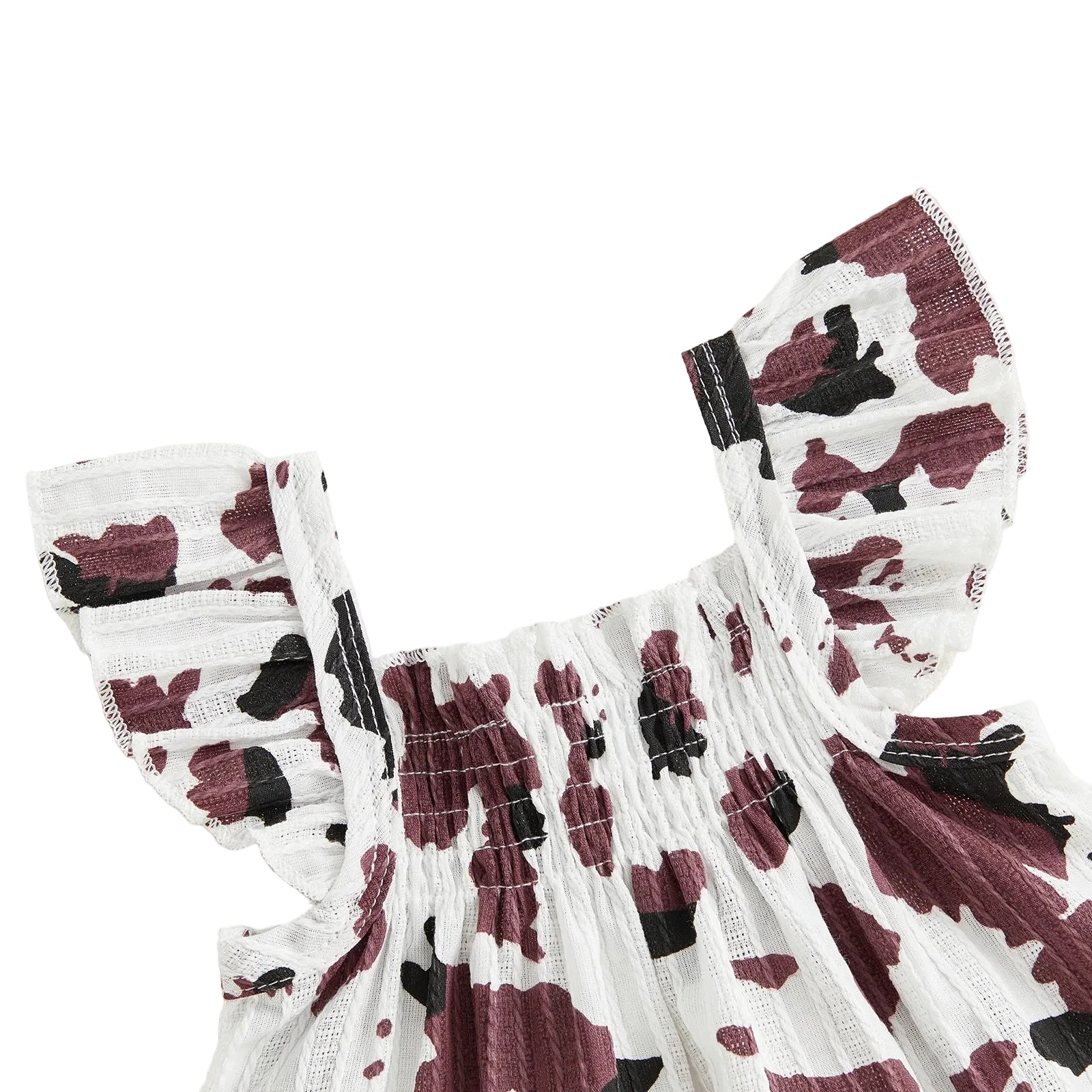 Close-up detail of the brown and white cow print smocked top featuring ruffled sleeves.