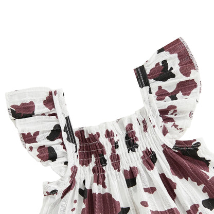 Close-up detail of the brown and white cow print smocked top featuring ruffled sleeves.