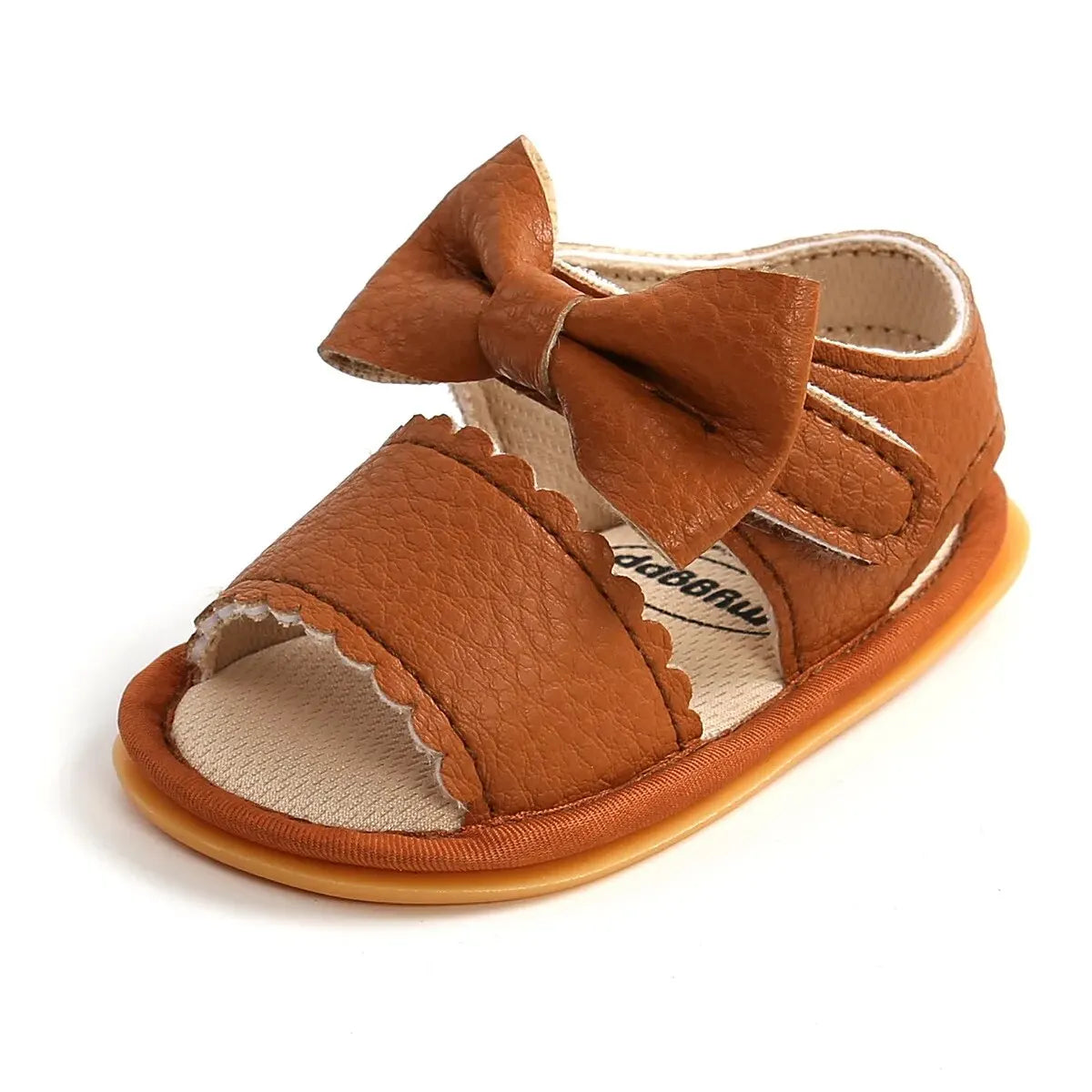 Side view of a single tan brown leather infant girl walking sandal showing the secure hook-and-loop closure system.
