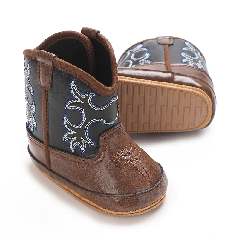 Pair of brown two-tone baby western boots with blue stitching, showing the anti-slip rubber sole.