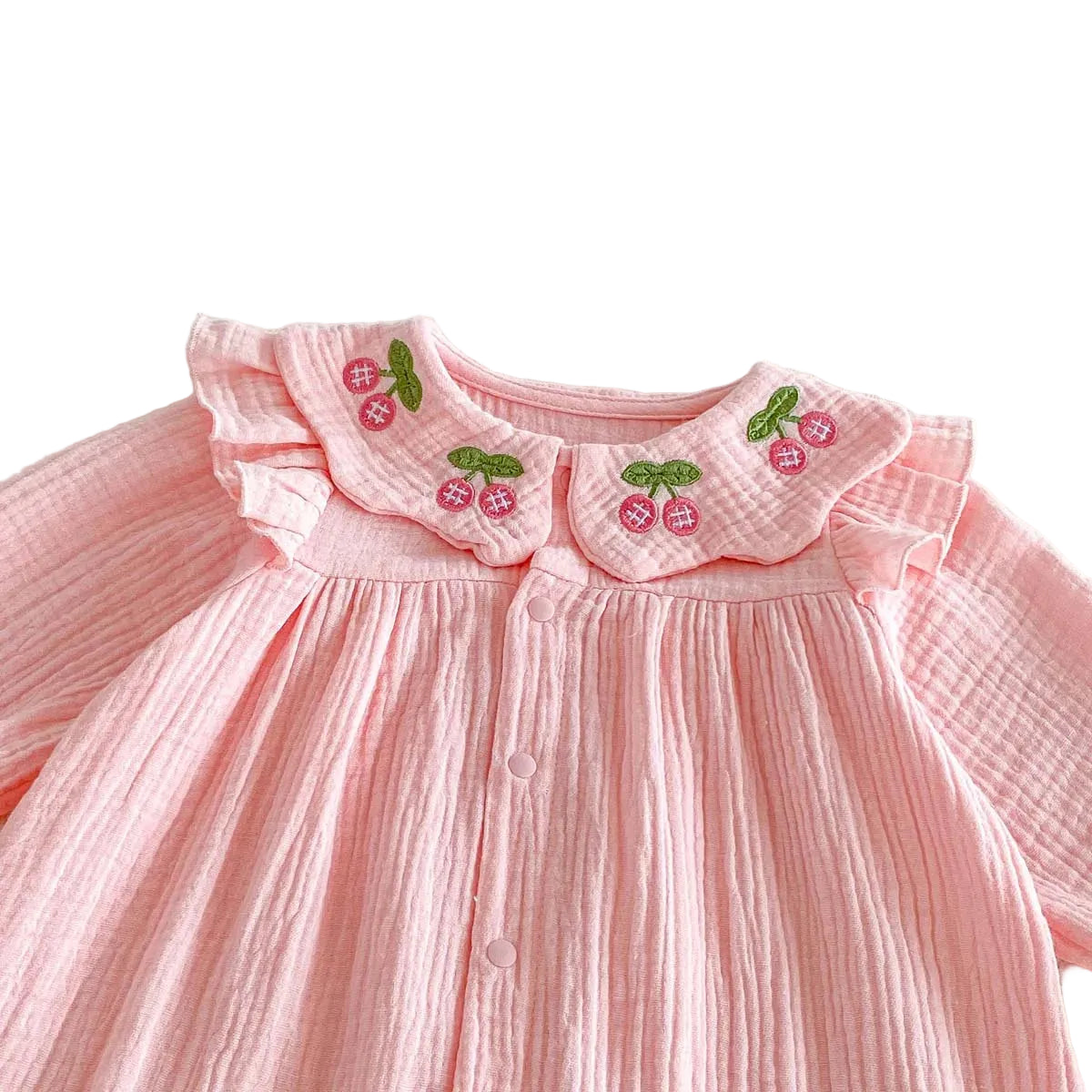 Close up of the sweet cherry embroidery and ruffle Peter Pan collar on the front of the Kidsely pink baby romper.