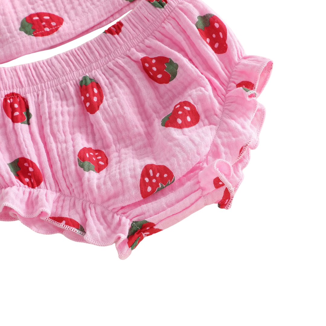 Close-up detail of the breathable 95% cotton crinkle gauze fabric and red strawberry berry print on pink and cream material.