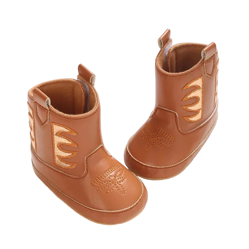 Two cognac brown baby cowgirl boots displayed at a top angle, highlighting the PU leather and classic western stitching.