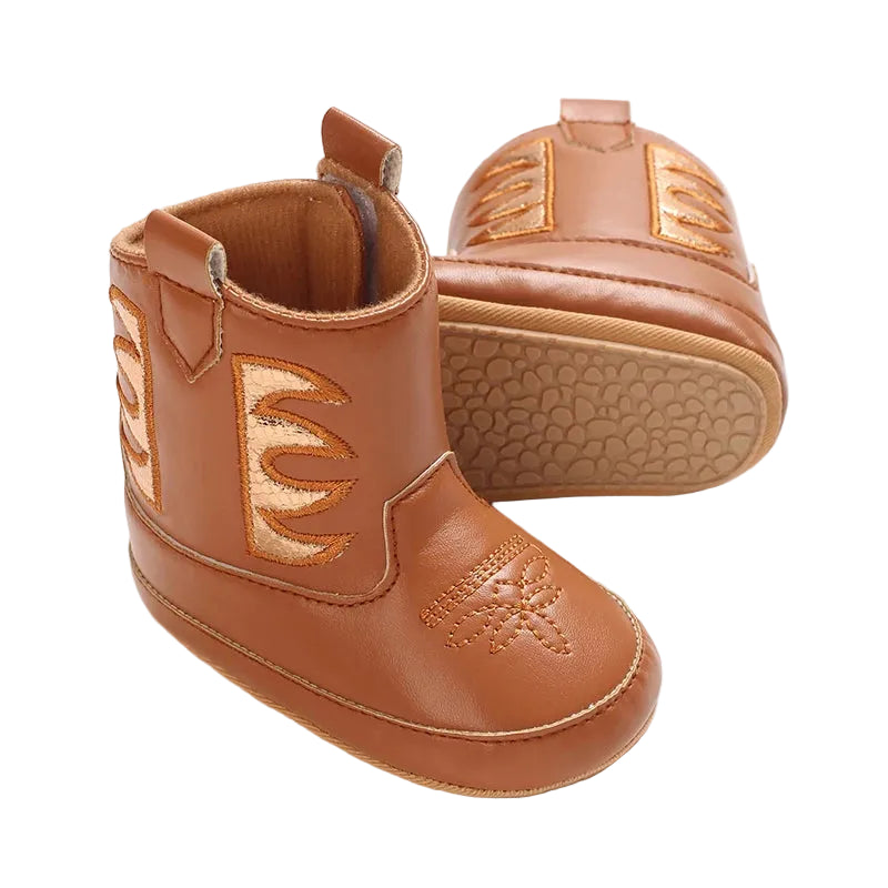 Side angle of cognac brown baby western boots showing the textured anti-slip rubber outsoles.