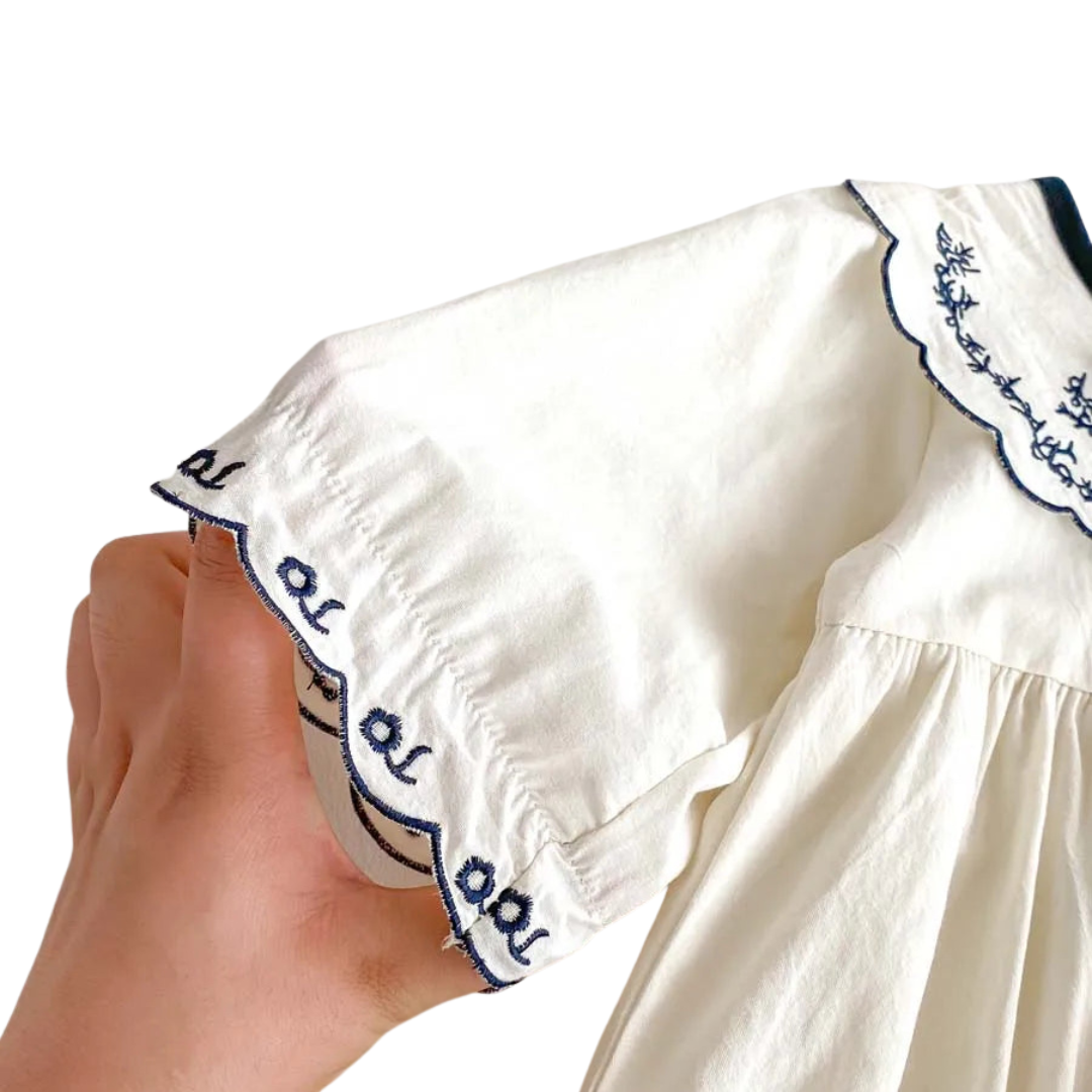 A close-up view of the soft, breathable 100% woven cotton fabric on the ivory bubble romper.