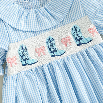Close up of the detailed chest smocking featuring embroidered blue cowgirl boots and pink bows.