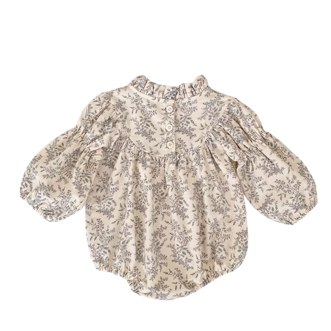 Full back view of the cream and gray floral baby bubble romper laid flat.