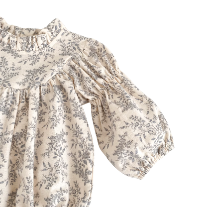 Close-up of the long puff sleeve and elastic cuff on the cream and gray floral baby romper.