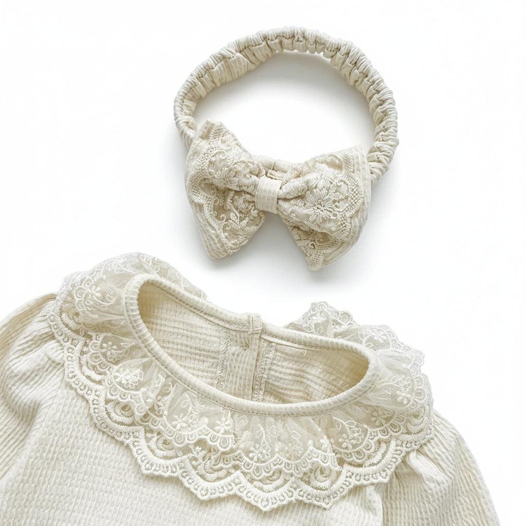 Top view showing the cream waffle knit baby romper collar paired with its matching lace bow headband.