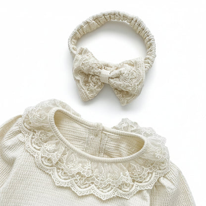 Top view showing the cream waffle knit baby romper collar paired with its matching lace bow headband.