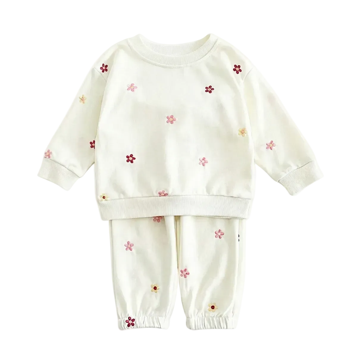 Full flat lay photo of a boutique off-white two-piece baby outfit, including a sweatshirt and joggers, decorated with small, multi-colored embroidered flowers on a white background.