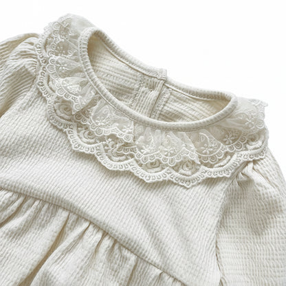 Detailed front view of the delicate cream lace trim collar on the off-white waffle knit infant romper.