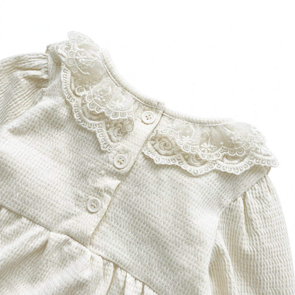 Back view detailing the neat stitching and button closures on the cream off-white baby girl bodysuit.
