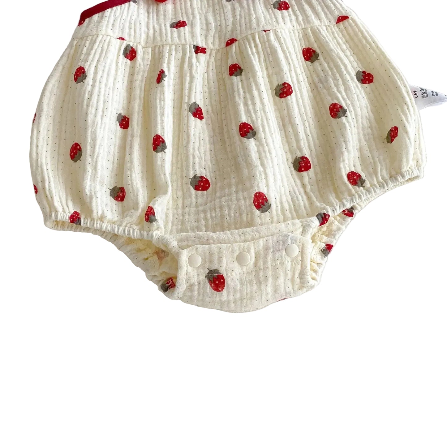 Close-up of the bottom back of the cream strawberry romper highlighting the flexible, elasticized leg openings.