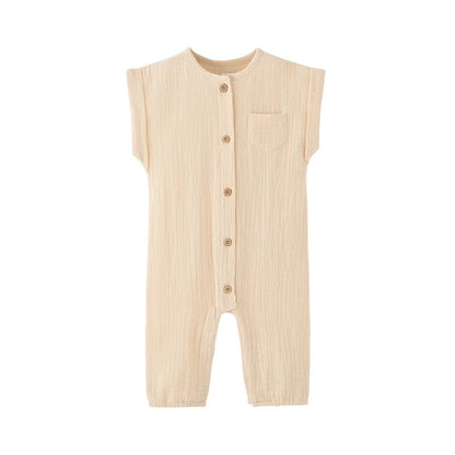 Front view of the vintage-inspired infant jumpsuit in a neutral cream beige, featuring a rolled cap sleeve and rustic buttons.