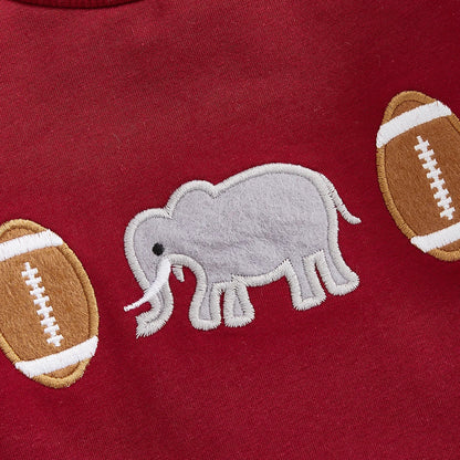 Close-up of high-quality vintage chain-stitch embroidery featuring a grey elephant and classic footballs on a crimson baby jumpsuit.