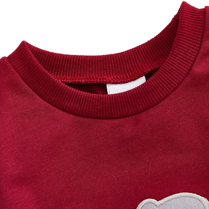 Close-up of the soft, ribbed crew neckline on the cozy crimson red infant and toddler game day jumpsuit.