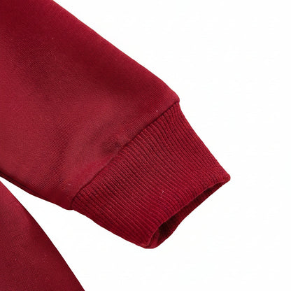 Close-up of the warm, banded long sleeve wrist cuff on a crimson red premium infant jumpsuit.