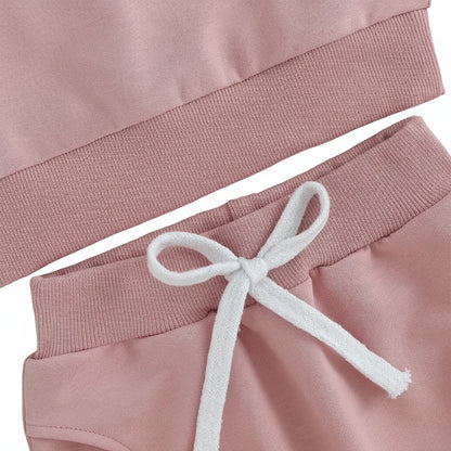Close-up of the comfortable elastic waistband featuring a decorative white drawstring on the pink baby sweatpants.