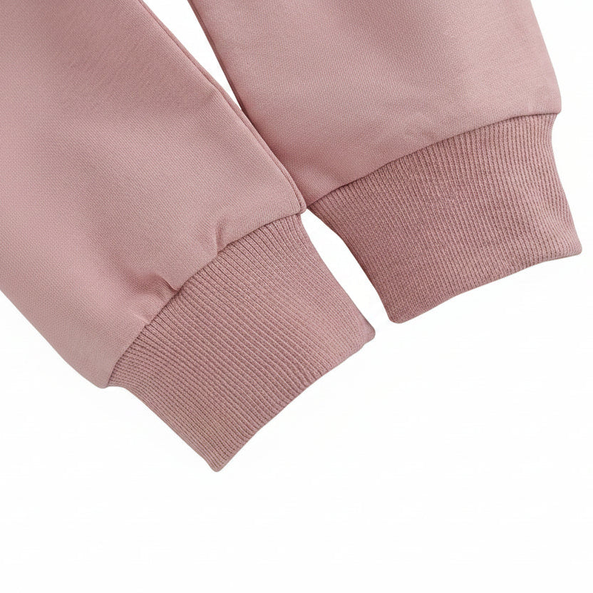 Close-up detail of the ribbed wrist cuffs on the long sleeve pink baby sweatshirt.