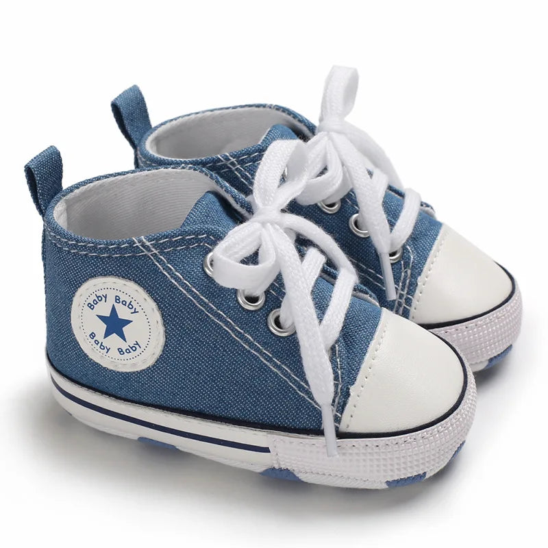 Denim blue fabric baby canvas sneakers with vintage high-top style and soft soles.