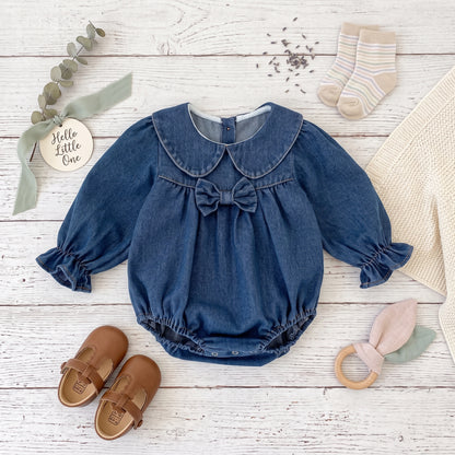 Flat lay of dark blue denim baby bubble romper with shoes and accessories