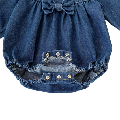 Open view of bottom inseam diaper snap closures on baby girl denim bubble romper