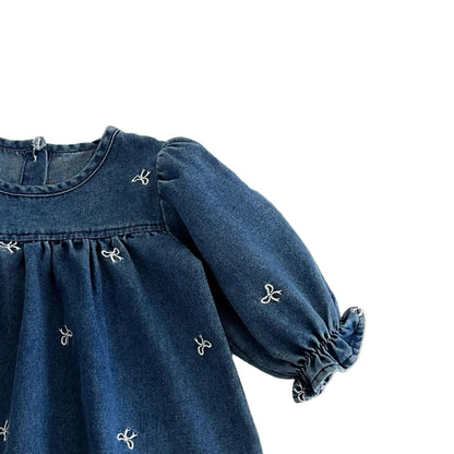 Close up of the long puff sleeve and soft elastic ruffled cuff on the blue denim bow dress.