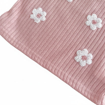 Zoomed-in macro shot of the textured ribbed knit fabric in dusty rose, highlighting the detailed loops on the white 3D floral embroidery patches.