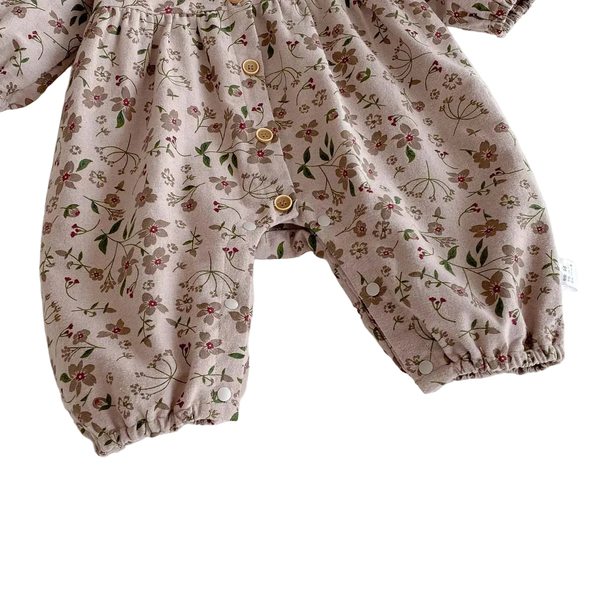 Close-up of the full-length pant legs featuring gently elasticized ankle cuffs and bottom snaps on the floral baby jumpsuit.