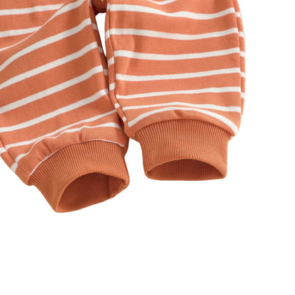 Close-up detail of the ribbed orange elastic ankle cuffs on the bottom of the striped baby and toddler jogger pants.