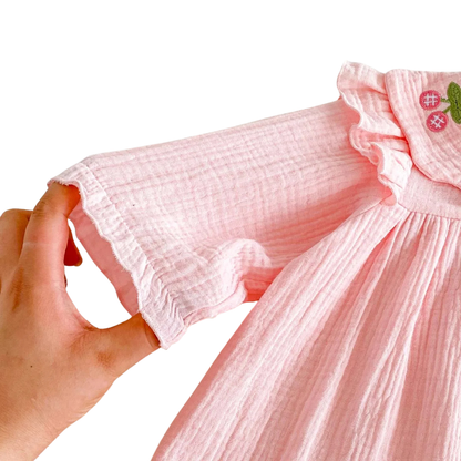 Hand demonstrating the gentle elastic stretch on the sleeve cuff of the Kidsely pink baby romper.