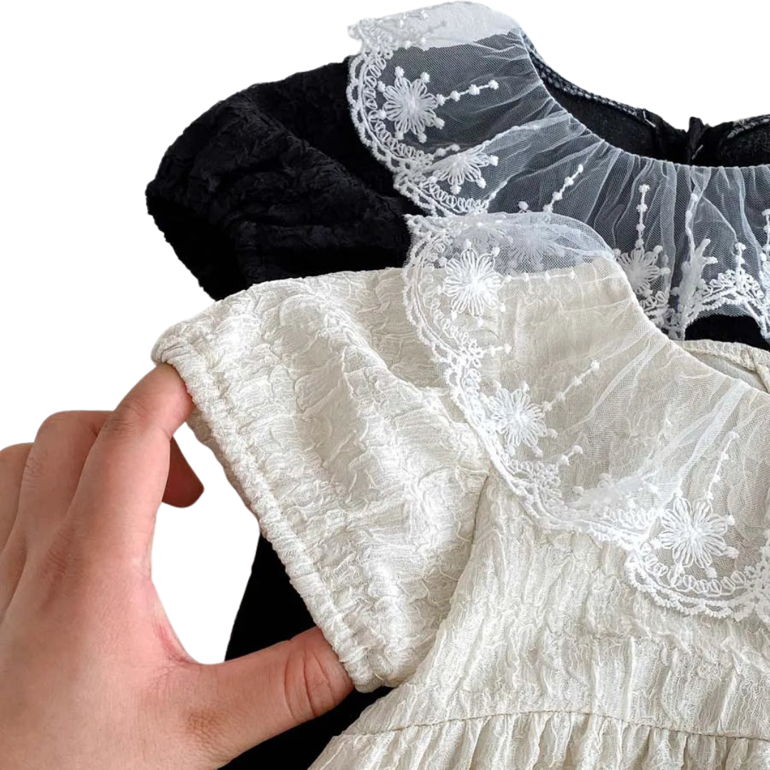 Close-up shot highlighting the soft elasticized puff sleeve and delicate lace trim of the Eleanor baby girl romper.