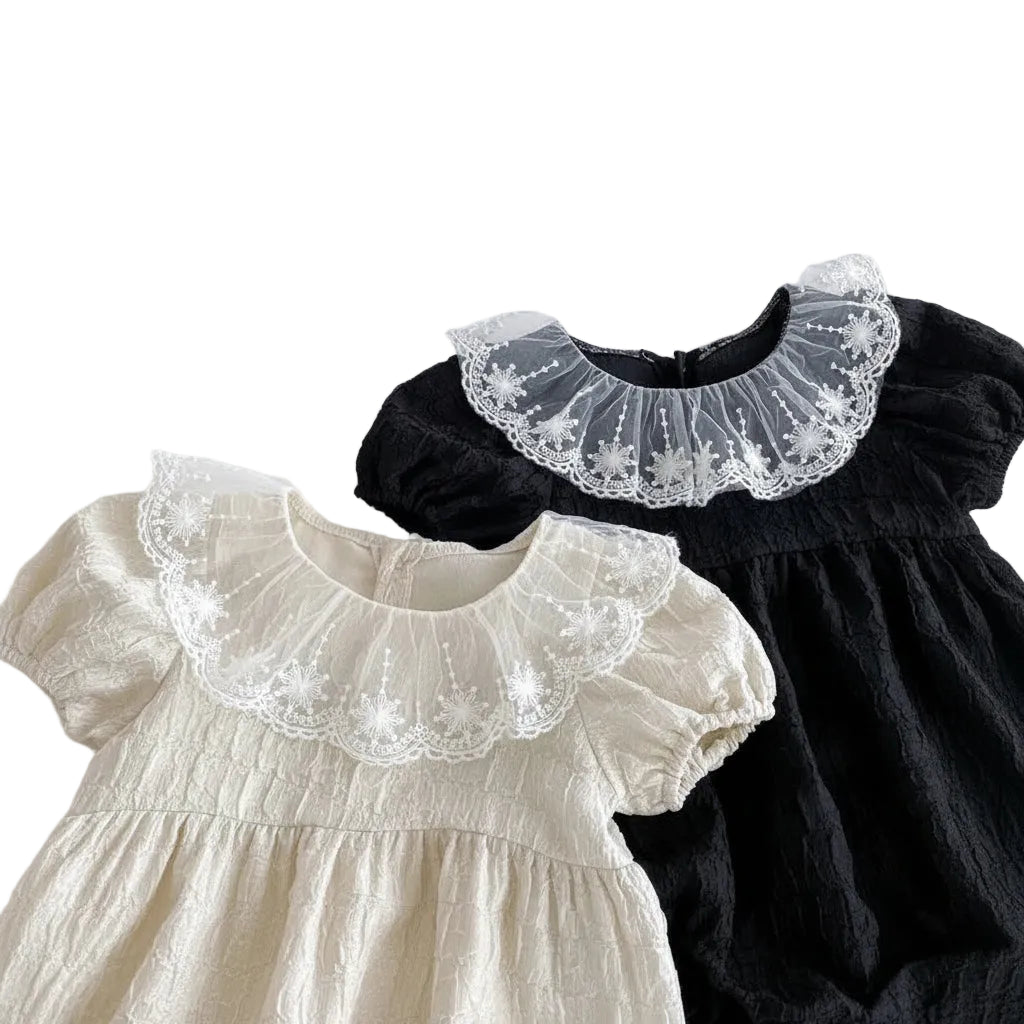 Side-by-side product view of the Eleanor special occasion baby outfits in Heritage Cream and Classic Noir.