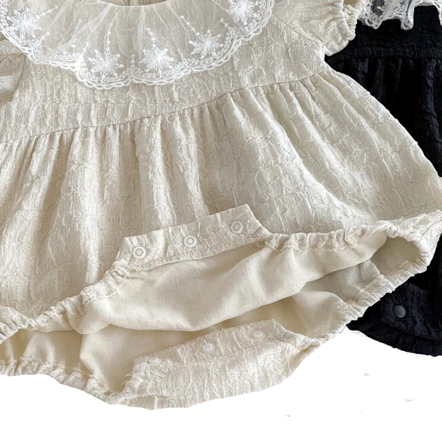Bottom view of the Eleanor baby romper showing the convenient, high-quality inner snap closures opened for easy diaper changes.
