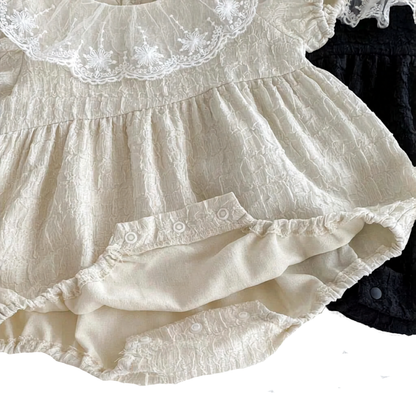 Bottom view of the Eleanor baby romper showing the convenient, high-quality inner snap closures opened for easy diaper changes.