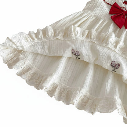 Close-up of the intricate white eyelet lace ruffle hem and premium fabric lining construction on the Kidsely baby dress.