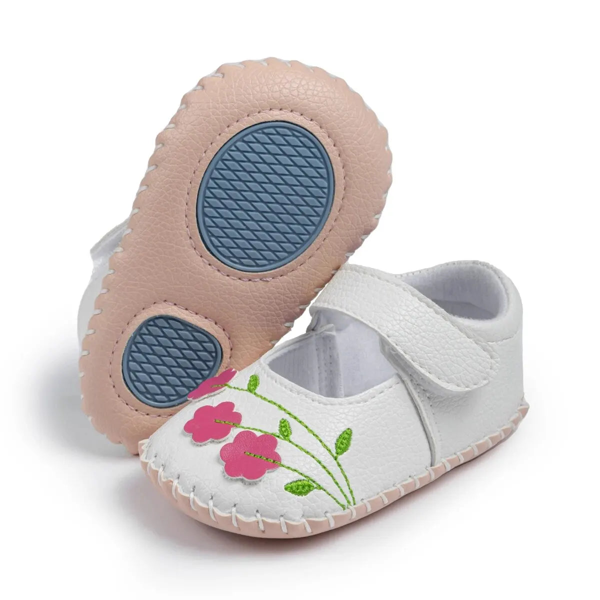 Bottom view of white baby first walker shoes showing the textured blue anti-slip rubber sole designed for traction.