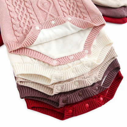Close-up showing bottom snap button closures and soft plush fleece lining on stacked baby knit rompers.