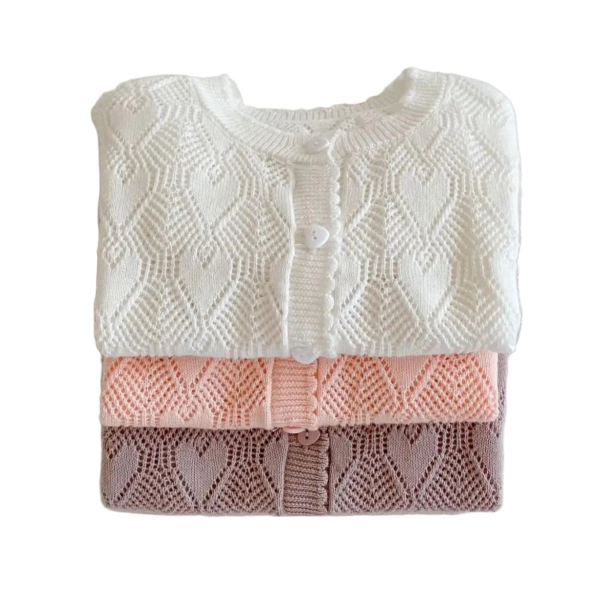 Stack of three baby girl cotton pointelle knit cardigans folded neatly in white, pink, and mauve colors.