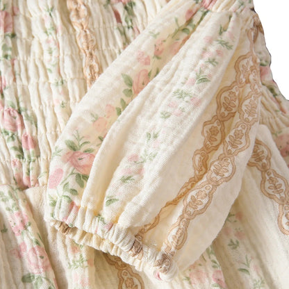 Close-up of the long balloon sleeve on a baby romper, showing the gathered elastic wrist cuff and delicate earthy lace trim.