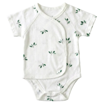Premium unisex white baby kimono bodysuit with a green botanical leaf print pattern, laid flat against a white background.