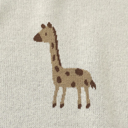 Close-up detail of the woven giraffe pattern on the soft cotton baby blanket