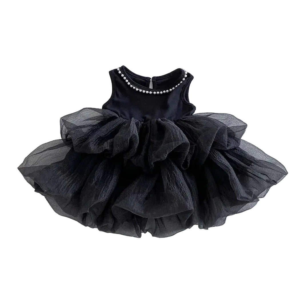A sleeveless black multi-tiered tiered tulle tutu dress with a single row of pearl accents on the round neckline, isolated against a clean white background.