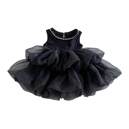 A sleeveless black multi-tiered tiered tulle tutu dress with a single row of pearl accents on the round neckline, isolated against a clean white background.
