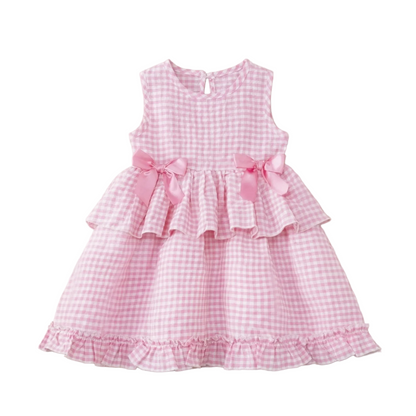 Flat lay of a girls sleeveless candy pink and white gingham dress with a tiered ruffle skirt and matching pink satin bows, styled for a 2026 summer pastoral aesthetic.