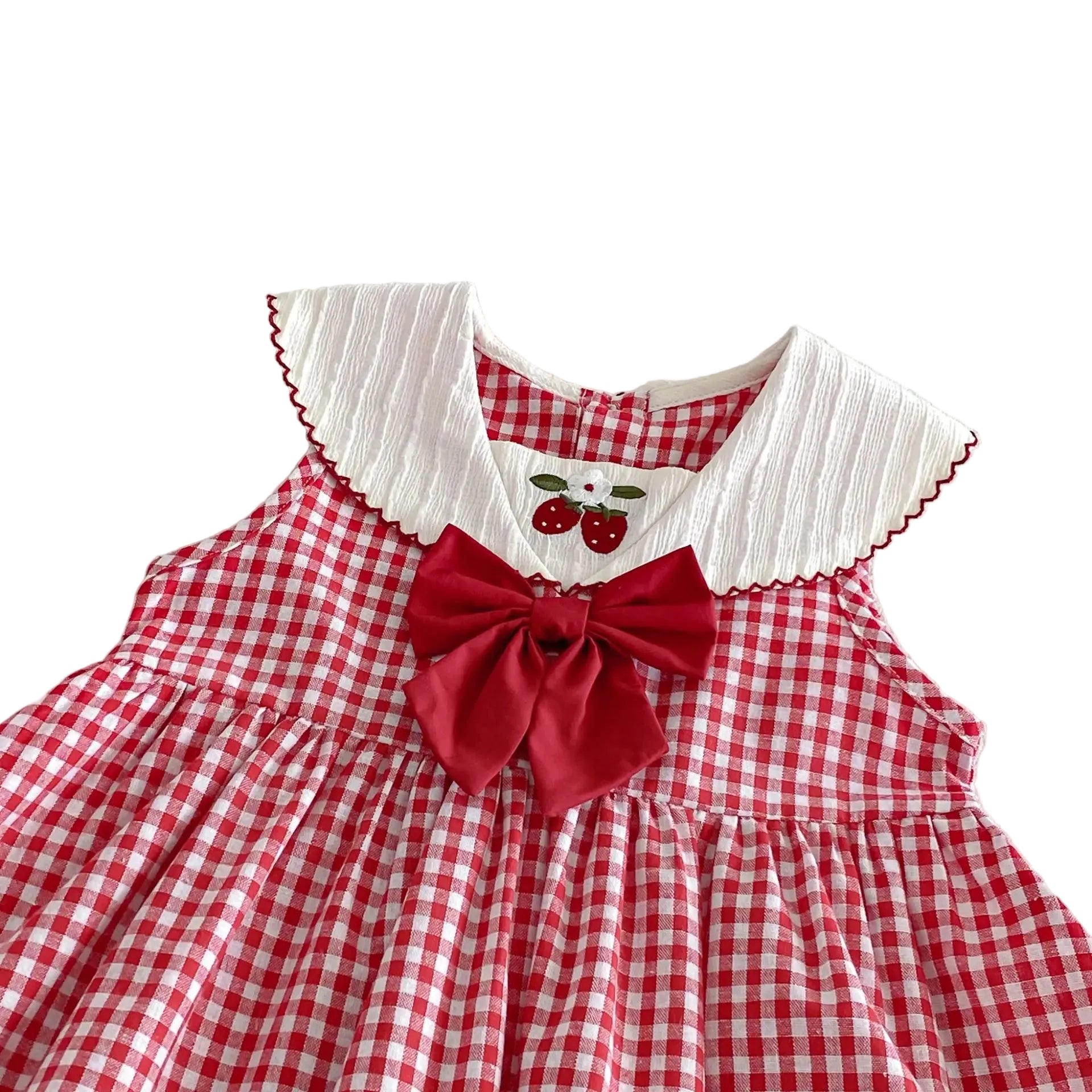 Red and white checkered dress with a large bow and white collar with strawberry details on a white background