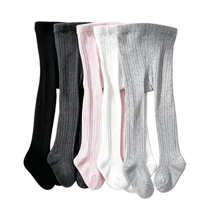 Detail shot showing the stretchy ribbed cable knit texture on a 5-pack bundle of neutral and pink girls tights.