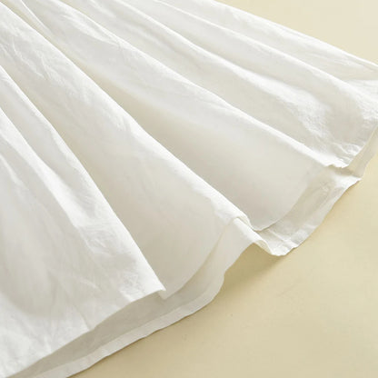 Close-up texture shot of the soft, lightweight white cotton fabric folds of the full A-line dress skirt.